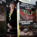 Australian Attorney-General Nicola Roxon with examples of the tobacco plain packaging and warning signs. Photo: Alex Ellinghausen